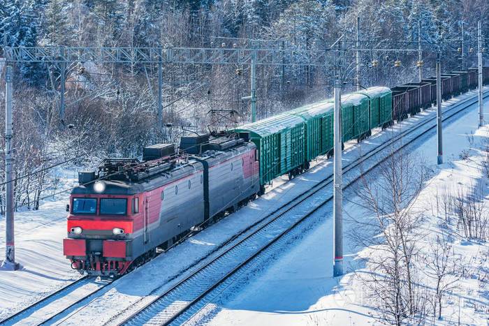 货运火车在冬季森林边行驶俄罗斯